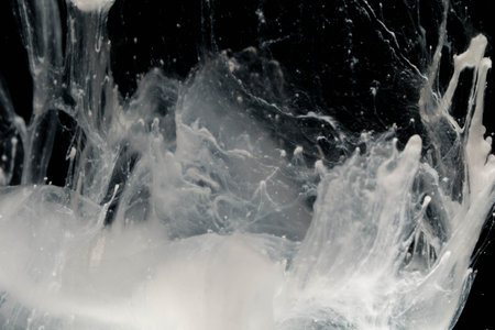 close up of white paint splash isolated on black background, abstract backgroundの写真素材