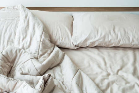 Messy bed with two pillows in the morning.