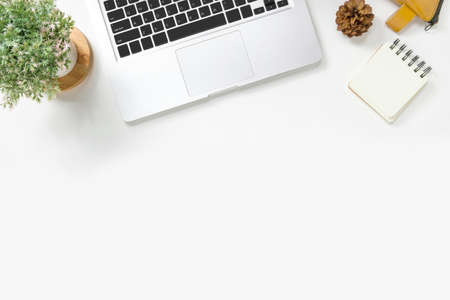Modern white office desk table with laptop and supplies. Top view with copy space, flat lay.