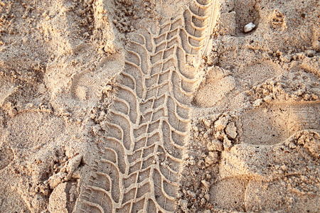 Tire ruts imprinted in the sand.の写真素材