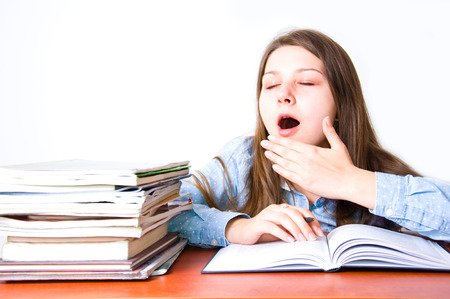 School and education conceptual image. Young cute girl get tired when learning with many books.の写真素材