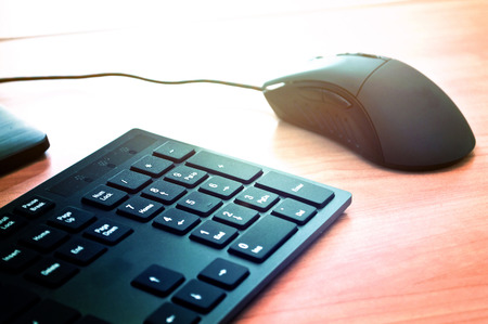 Computer mouse and keyboard on the office table. Computer technology conceptual image.の写真素材