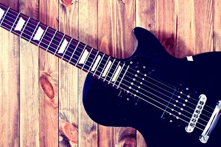 Guitar conceptual image. Picture of electric guitar lying on wooden background. Retro vintage ...