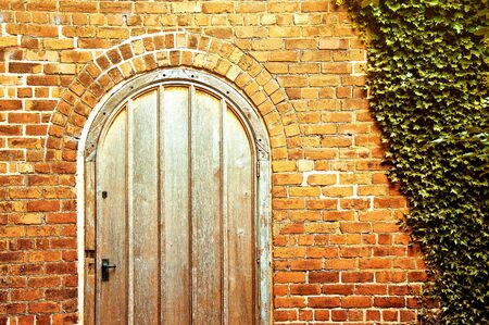 Old door in the brick wall. Old portal to the new life.の写真素材