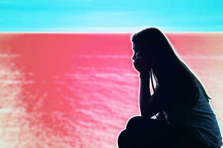 Sad lonely teenage woman over psychodelic background. Mental health conceptual image.