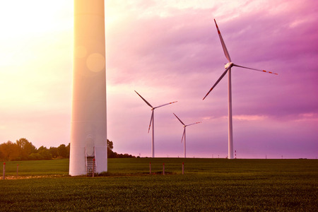 Windmills on the windfarm agriculture land. Field  and sky at sunset. Green renewable alternative energy source.の写真素材