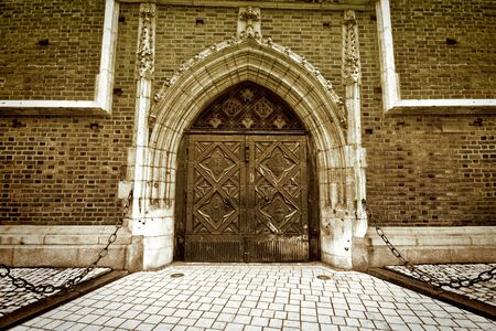 Old gothic door and the brick wall. Architecture. Sepia.の写真素材