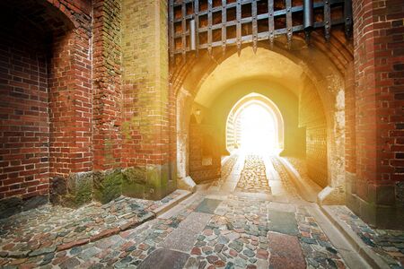 Old medieval entrance gate bathed in the light of the sun.の写真素材