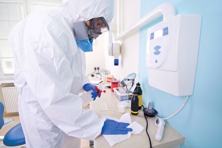 Doctor in protective suit uniform and mask cleans the laboratory. Coronavirus outbreak. Covid-19 concept.の写真素材