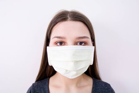 Young woman wears a face mask. Isolated image. Covid-19 concept.の写真素材