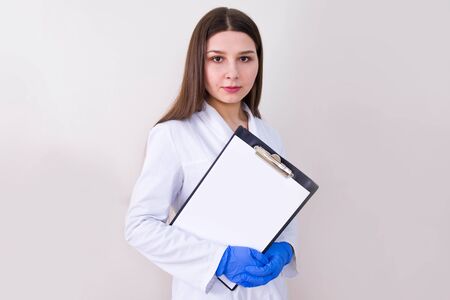 Female doctor wearing protection gloves and holding notes. Free copy space. Covid-19 concept.の写真素材
