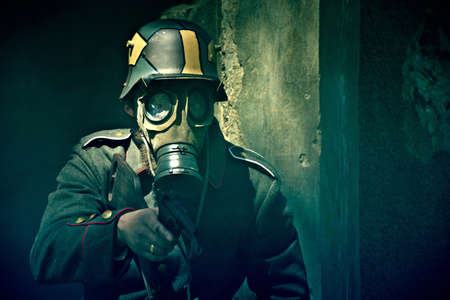 World War 2 Soldier in a gas mask aims his gun. War concept.の写真素材