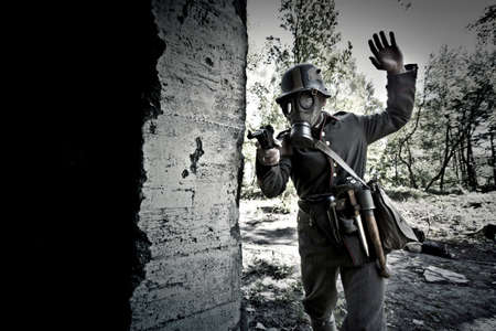 World War 2 Soldier in a gas mask aims his gun. War concept.の写真素材