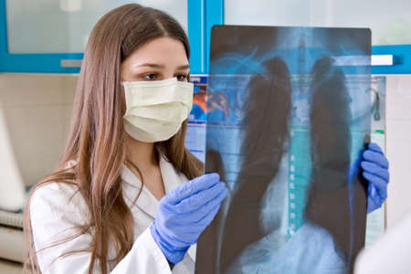 Female doctor in the hospital looks at the x-ray of the lungs.の写真素材