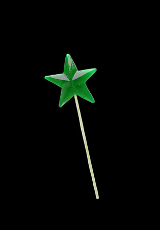 Homemade lollipop. Green star shaped lollipop isolated on black backgruond.の写真素材
