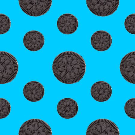 Chocolate cookies on blue background top view, seamless patternの写真素材