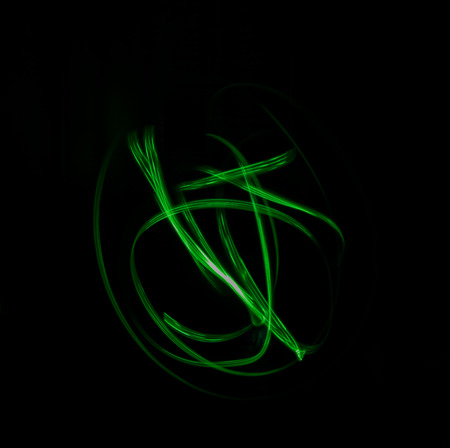 Freeze light photo, abstract streaks light green color on black background, made with light painting or light drawingの写真素材
