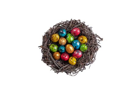 Quail eggs for Easter in a nest of branches. Isolated on a white background, Repainted in different colors.の写真素材