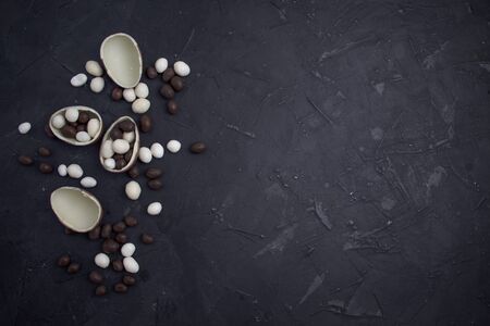 Chocolate easter eggs and sweets on dark background.