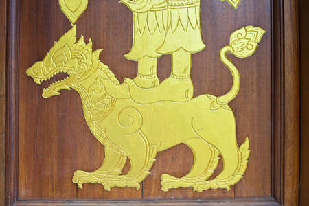 Gold leo on thai church door の写真素材