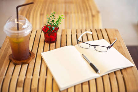 coffee notebook glasses and pen on bamboo table の写真素材