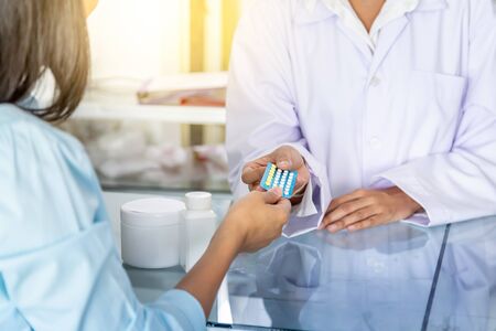 Doctor or Pharmacist recommend how to use the birth control pills for customers. Contraceptives, Healthcare, medical and pharmacy concept.の写真素材