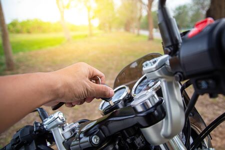 Man hands are inserting the key and starting the engine. Motorcycle ignition action.の写真素材