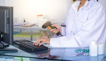 Pharmacist is scanning barcode of medicine in a pharmacy drugstore. Health care and medical concept.の写真素材