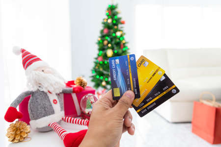 Christmas online shopping-Hand of female holding credit card for buys presents, prepare to xmas eve.の写真素材