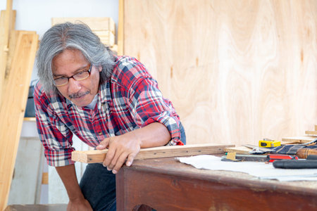 Carpenter man working in woodwork workshop. The wooden industry. Invention and crafts concept.の写真素材