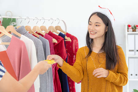 Asian young women taking a credit card from customer for payment. Business concept.の写真素材