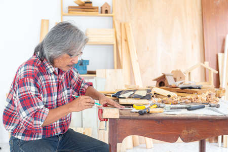 Asian carpentry using hammer and chisel to produce wood products. The wood industry. Invention and crafts concept.の写真素材