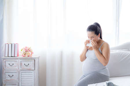 Asian pregnant women have nausea and dizziness due to morning sickness.の写真素材