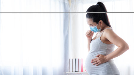 Asian pregnant women wearing medical masks due to illness, cough, sneeze, dizziness. Healthy pregnancy concept.の写真素材