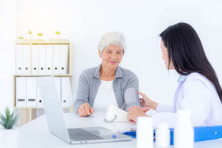 Female doctor examining senior patient at clinic. Healthcare, medical, treatment and elderly diseases concept.の写真素材