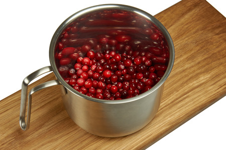 Cranberries in pot on white background
