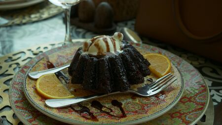 A piece of chocolate cake with vanilla on the table, close-up
