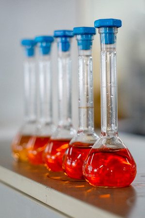 fade red-orange solution in cylinder flask