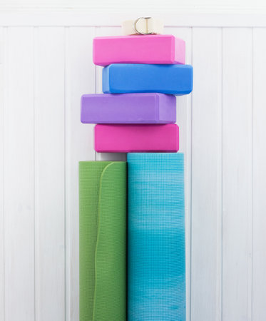 Varicolored yoga props. Blocks, strap and carpets on woody backgroundの写真素材