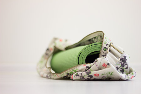 Green yoga mat in the bag laying on the floor