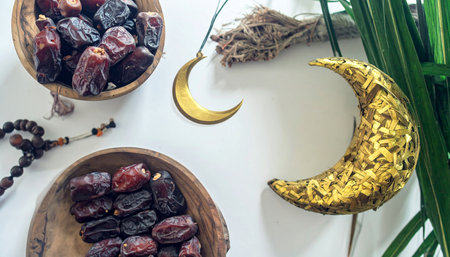Ramadan Kareem concept. Top view of dates and crescent moon on white backgroundの素材