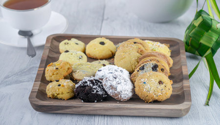 Homemade cookies with raisins and chocolate chips on a wooden plateの素材