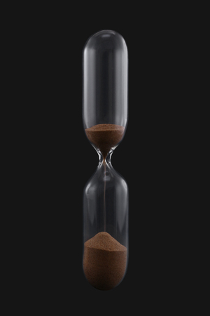 Vertical glass five minutes sand clock isolated on the grey background.の写真素材