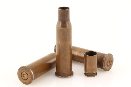 Three 7.62 mm caliber rifle and one 9 mm caliber pistol old bullet casings on a light background...