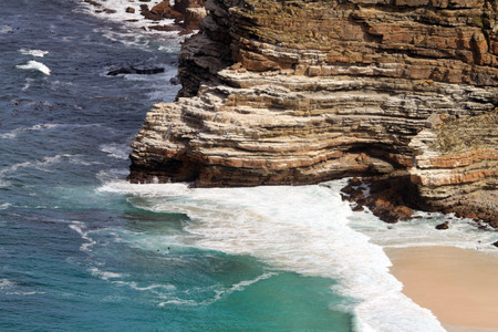 Scenic view of sea waves with clean green and blue water, hitting the rock of the mountain, in South Africaの写真素材
