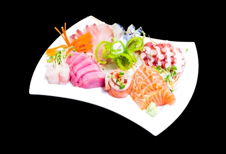 Mixed sashimi in white plate isolated on black backgroundの写真素材