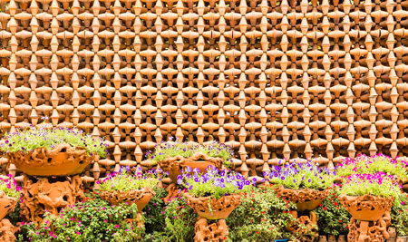 colorful flowers with decorative wall of pottery pots の写真素材