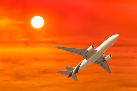 commercial airplane flying with sunset background