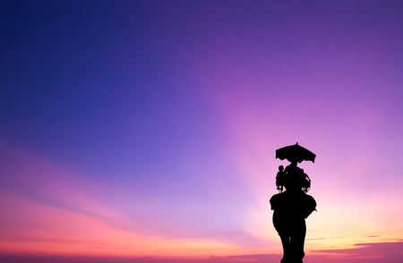silhouette elephant with tourist at sunsetの写真素材