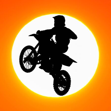 silhouette of motocross rider jump in the sky at sunsetの写真素材